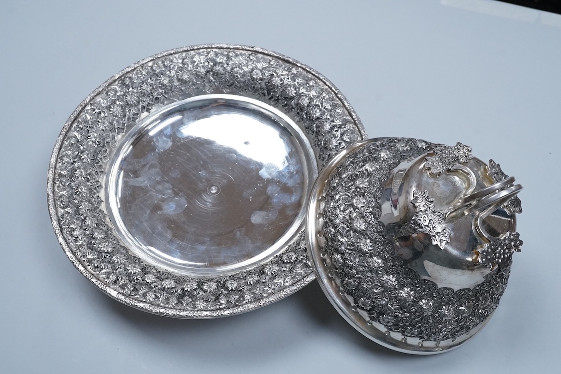 A 20th century Middle Eastern white metal circular dish and cover, embossed with flower heads, stamped '84', base diameter 24.2cm, 28.2oz.